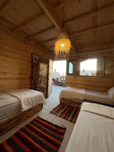 a bedroom with two beds and a chandelier at Heaven Surf Morroco in Tamraght Ouzdar +118 photos