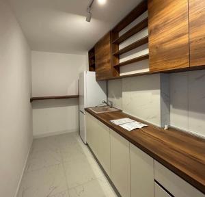 a kitchen with white cabinets and a wooden counter top at Moon night in Niš