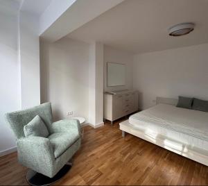 a bedroom with a bed and a chair at Moon night in Niš