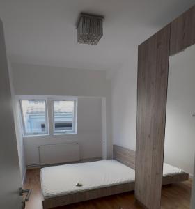 a small room with a bed and two windows at Moon night in Niš +4 photos