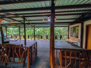 a covered porch with a bench and a swing at Amisacho in Nueva Loja