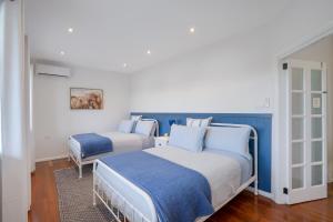 Salt AshThe Ranch - Coastal Farmhouse bringing family and friends together的蓝白相间的房间里有两张床