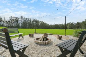 Salt AshThe Ranch - Coastal Farmhouse bringing family and friends together的公园里两个长椅和一个火坑
