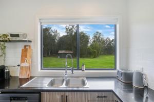 Salt AshThe Ranch - Coastal Farmhouse bringing family and friends together的带水槽和大窗户的厨房