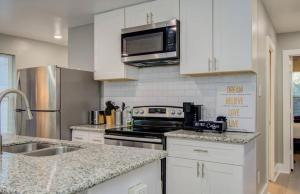 a kitchen with white cabinets and stainless steel appliances at 2-Bedroom Townhouse in Houston in Houston