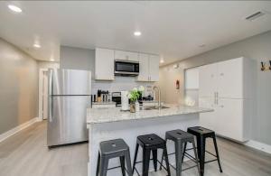 a kitchen with a counter with stools and a refrigerator at 2-Bedroom Townhouse in Houston in Houston