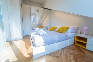 a bedroom with a large white bed with yellow pillows at BRERA LittleSuite DuomoView in Milan