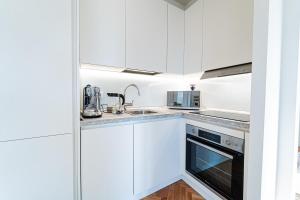 a white kitchen with white cabinets and a sink at BRERA LittleSuite DuomoView in Milan