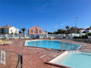 a large swimming pool in a yard with a fence at HDFM Collection - Sea Garden in Playa del Ingles
