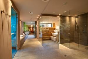 a bathroom with a walk in shower and a glass door at Hotel Bäckelar Wirt Superior in Sölden