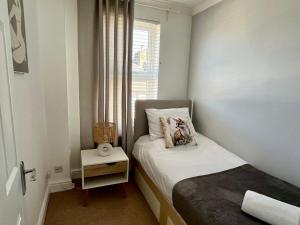 Un dormitorio pequeño con una cama y una ventana. en Red Fox House Medway Free Parking, en Chatham