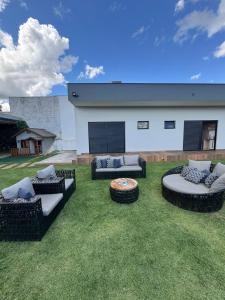 a patio with couches and a table in the grass at Chácara de alto padrão in Água Boa