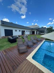 a deck with chairs and a swimming pool at Chácara de alto padrão in Água Boa