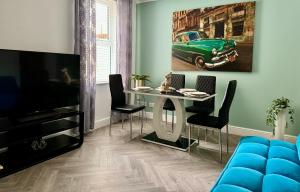 Una sala de estar con una mesa y un coche verde en la pared. en Red Fox House Medway Free Parking, en Chatham