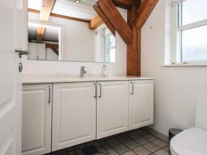 a white bathroom with a sink and a mirror at 4 person holiday home in Blåvand in Blåvand +14 photos