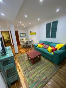 a living room with a blue couch and a table at THE HEIRS Departamentos in Posadas