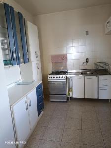 a small kitchen with a stove and a sink at Apartamento central in Uruguaiana