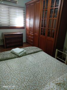 a bedroom with a bed and a wooden cabinet at Apartamento central in Uruguaiana