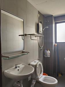 ein Badezimmer mit Waschbecken, Toilette und Spiegel in der Unterkunft Pangkor L30 88 Corner villa House in Pulau Pangkor