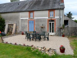 un tavolo e sedie di fronte a una casa di Chez Beaumont - Gite a Saint-Sébastien