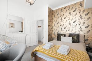a bedroom with a bed and a wall with birds on it at Bliss on the Bay in Eastbourne