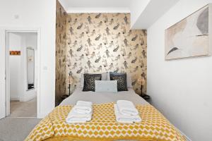 a bedroom with a large bed with a yellow blanket at Bliss on the Bay in Eastbourne