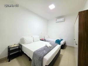 a hotel room with two beds and a window at Casa 2 quartos 2 banheiros 5 min centro 15 cataratas in Foz do Iguaçu