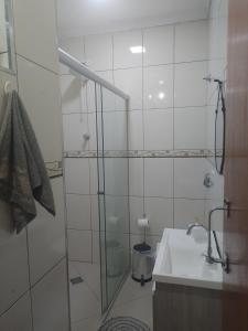 a bathroom with a glass shower and a sink at Casa completa a 10 min do aeroporto Guarulhos in Guarulhos +8 photos