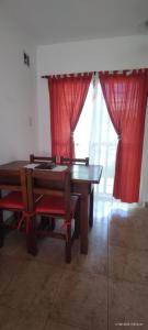 a dining room with a table and red curtains at Aires de Fresnos in San José