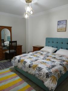 a bedroom with a bed and a desk and a chair at 378 Pyramids apartment in Nazlet el-Sîsi