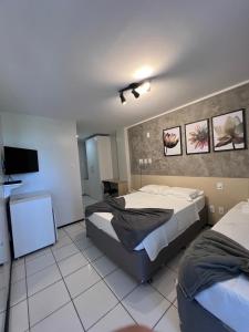 a bedroom with two beds and a flat screen tv at Gran Lençóis Flat Residence in Barreirinhas +20 photos