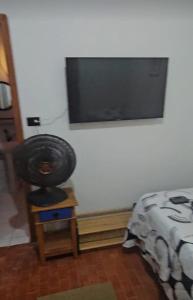 a bedroom with a flat screen tv on the wall at CASA COLONIAL Ilha da Croa in Barra de Santo Antônio