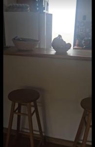 a counter with two bar stools and a window at CASA COLONIAL Ilha da Croa in Barra de Santo Antônio