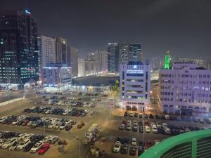 a city at night with cars parked in a parking lot at DOS #FaMiLy RooM AwAy Fr0m HoMe in Abu Dhabi