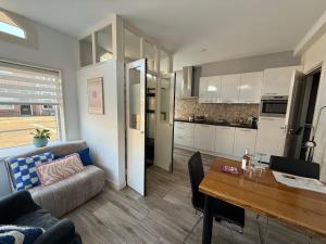Una cocina y una sala de estar con un sofá y una mesa. en Sunset bliss, en Katwijk