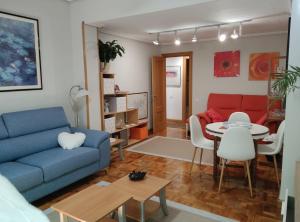 a living room with a blue couch and a table at BIENVENIDOS a CASA PINO CENTRO in Logroño