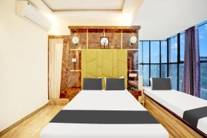 a bedroom with two beds and a large window at Super Collection O DIVIRA INN in Dhanbād