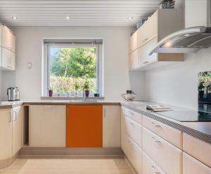 a kitchen with white cabinets and a window at Home in Billund in Billund