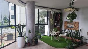a living room with a table and chairs and plants at Desk and Dream Room in Panama City +1 photo
