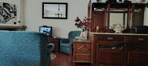 a living room with two blue chairs and a mirror at Room das Lindos in Mondim de Basto