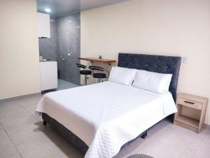 乔阿奇Apartaestudio Casablanca Choachí的一间卧室配有一张白色的床和黑色床头板