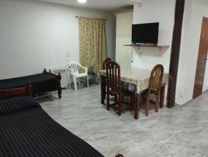 a living room with a table and chairs and a television at Manuel Apart in Esquina