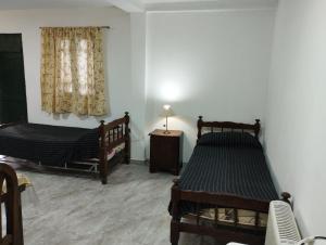 a room with two beds and a table and a window at Manuel Apart in Esquina