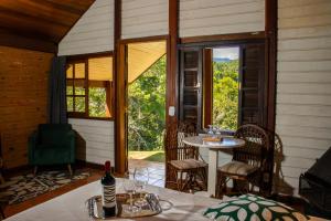 a room with a table and chairs and a window at Pousada Olivier da Montanha in Santo Antônio do Pinhal