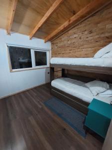 a room with two bunk beds and a window at Cabaña Entre Bosque in Puelo