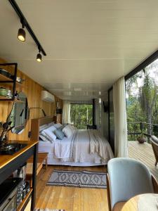 a bedroom with a bed and a balcony at Vale Dos Pinheiros in Rio Forcação