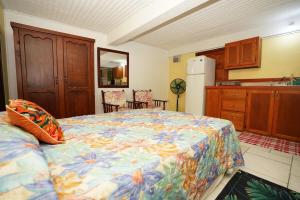 ein Schlafzimmer mit einem Bett mit einer farbenfrohen Tagesdecke in der Unterkunft KC's apartment in Gros Islet
