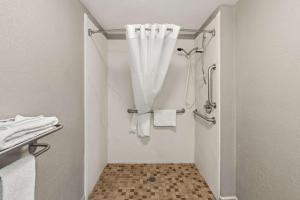 a bathroom with a shower with white towels at Motel 6 Lester - Philadelphia Airport in Lester +23 photos