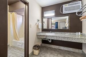 a bathroom with a sink and a mirror at Economy Inn Barstow in Barstow +20 photos