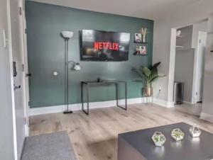 uma sala de estar com uma televisão na parede em Stylish & Cozy #1 8 mins to DCA & Washington DC em Alexandria